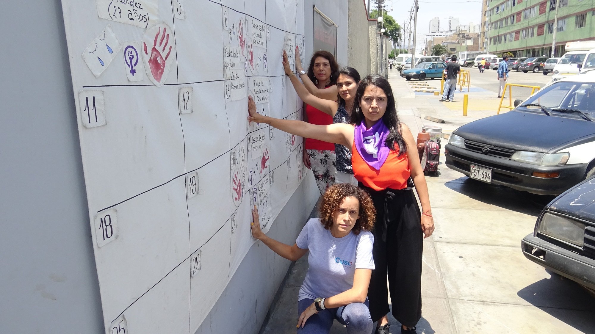 Group of woman putting handprints on large calendar