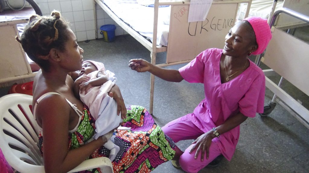 Woman with newborn baby talking to nurse