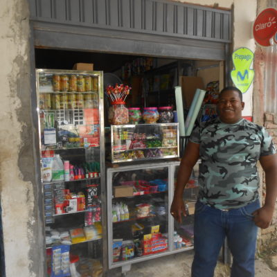 Man in front of small shop