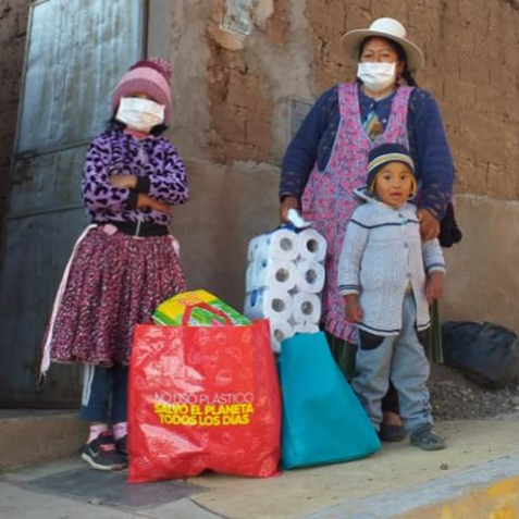 Woman and two  children  wearing face masks holding package of toilet paper
