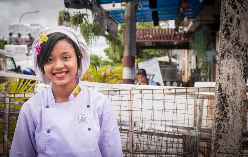 A woman in chef's outfit smiling