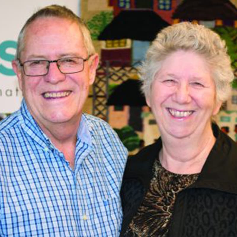 A man and woman smiling at the camera