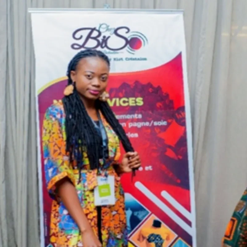 Young woman standing beside program banner / Jeune femme debout près d’une bannière de programme