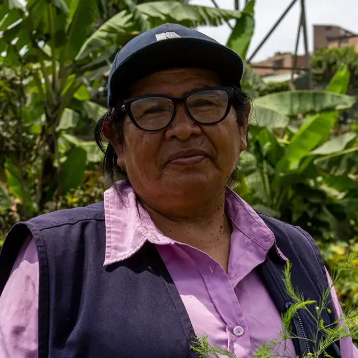 Individual with glasses and a cap, enjoying the lush greenery, embodies Cuso International's spirit in Peru.