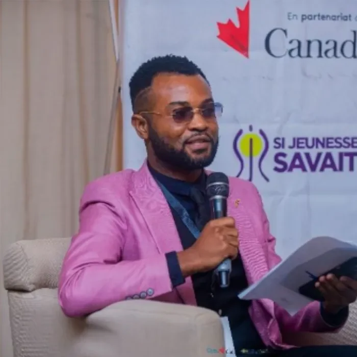 Male speaker addressing audience with microphone / Intervenant masculin s’adressant au public avec un micro