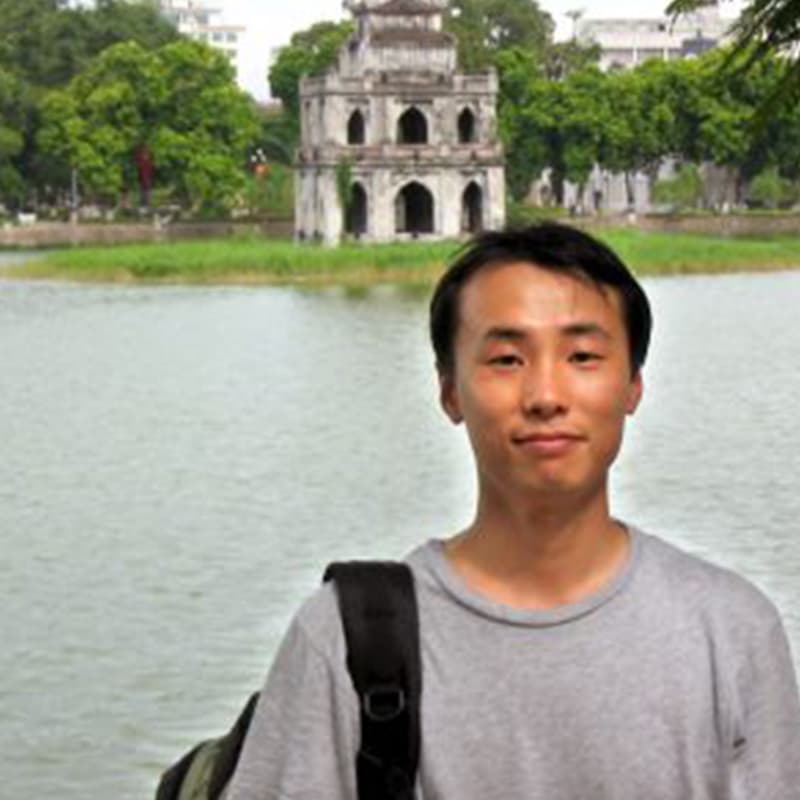 Byung standing in front of a lake