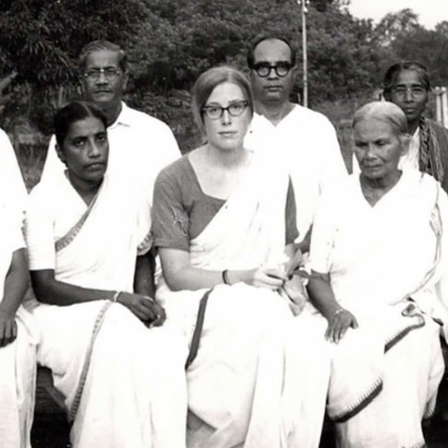 A white woman in a sari sitting amongst a group of South Asian adults