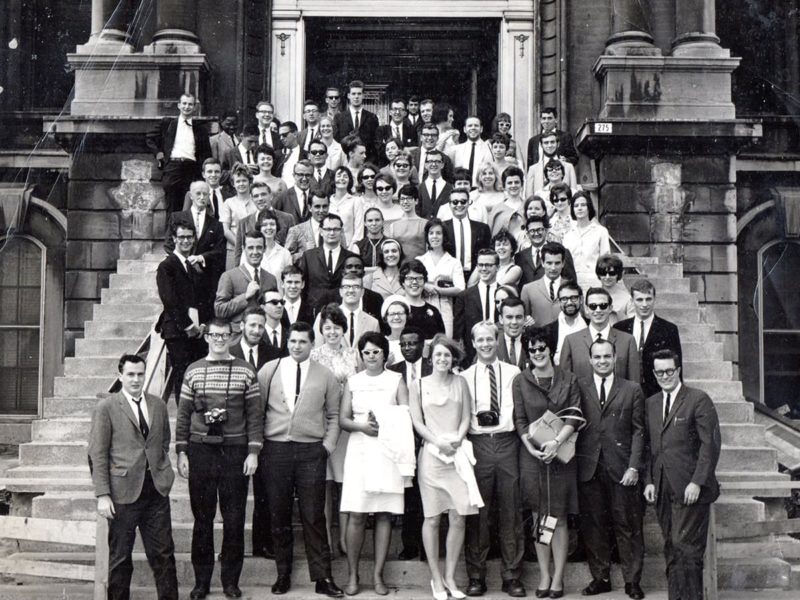 A group of about 30 people standing on steps, black and white