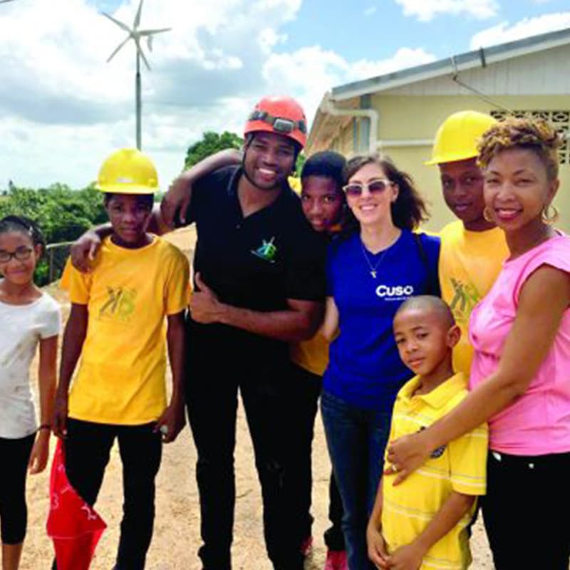 Christine French standing with a family wearing pink and yellow