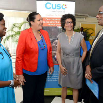 People talking in front of a cuso sign