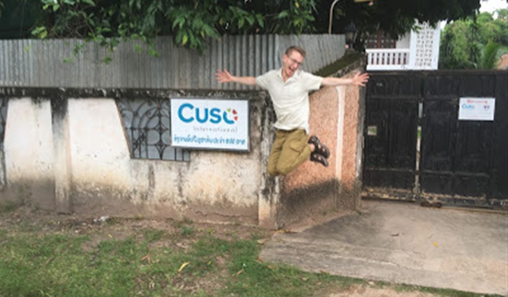 Man jumping in front of Cuso sign