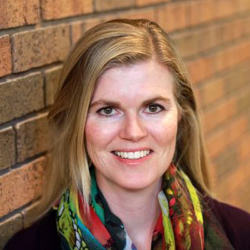Kelly standing against a brick wall