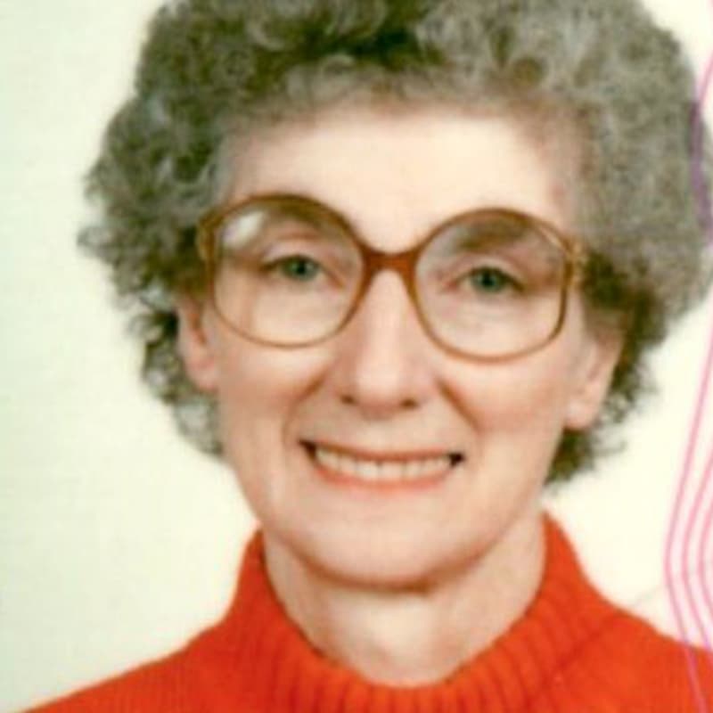 Lois looking at the camera wearing a bright red turtleneck