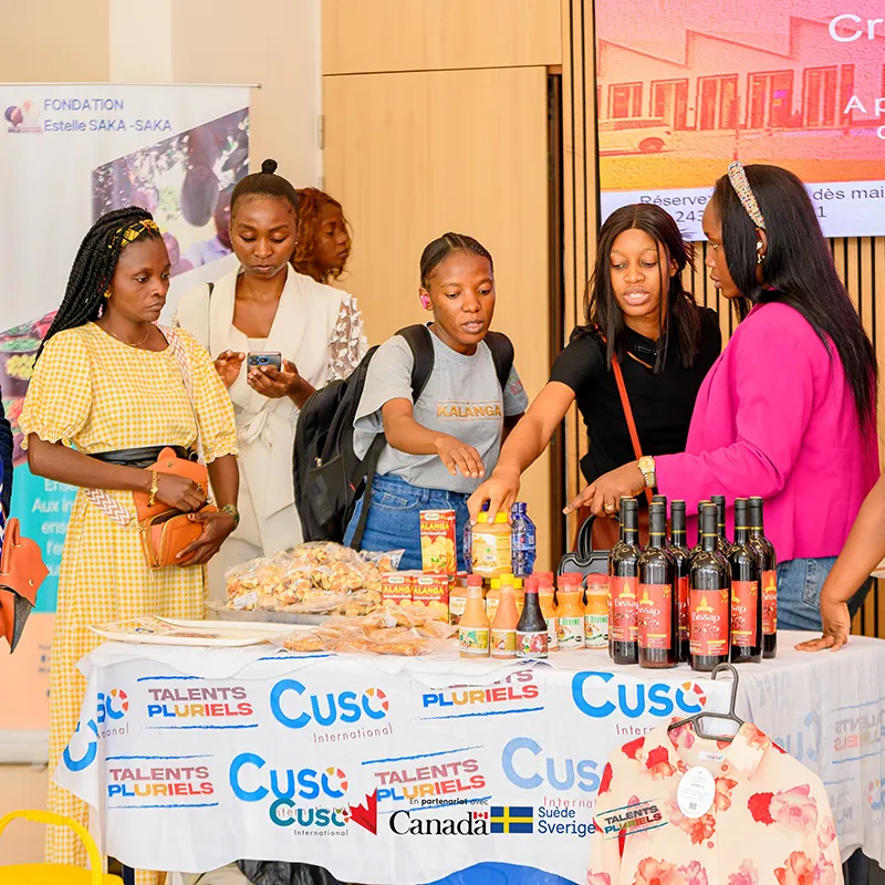 Women gathered around products at a small enterprise showcase / Femmes rassemblées autour de produits lors d’une vitrine d’entreprise locale
