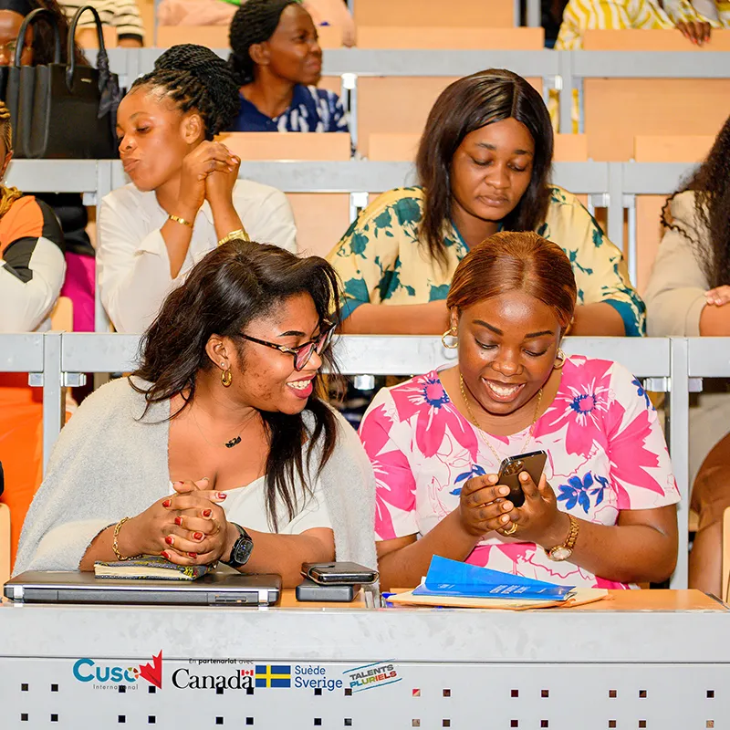 Women reviewing materials together at a community table / Femmes examinant des documents autour d’une table communautaire