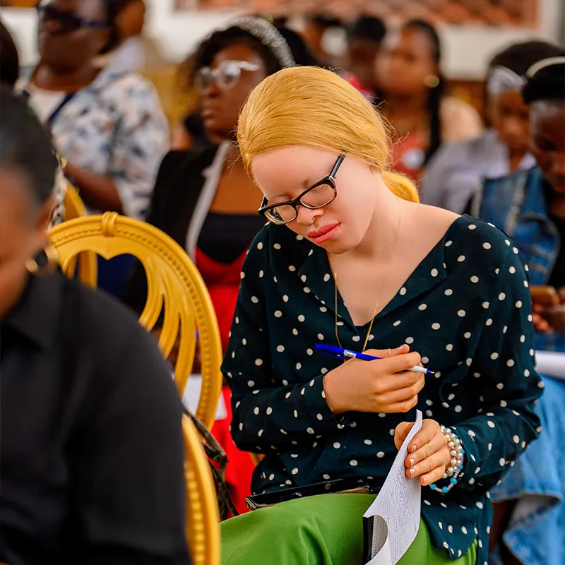 Woman writing notes during a community workshop / Femme prenant des notes pendant un atelier communautaire